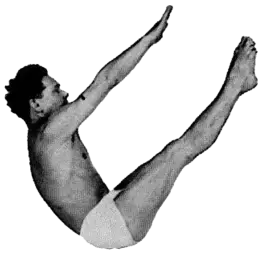 Sort-hvidt foto af en mand, der udfører en klassisk Pilates-øvelse i bådposition.